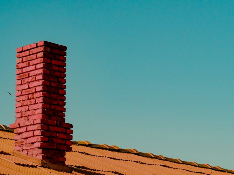 A brick chimney passing through a roof slope
